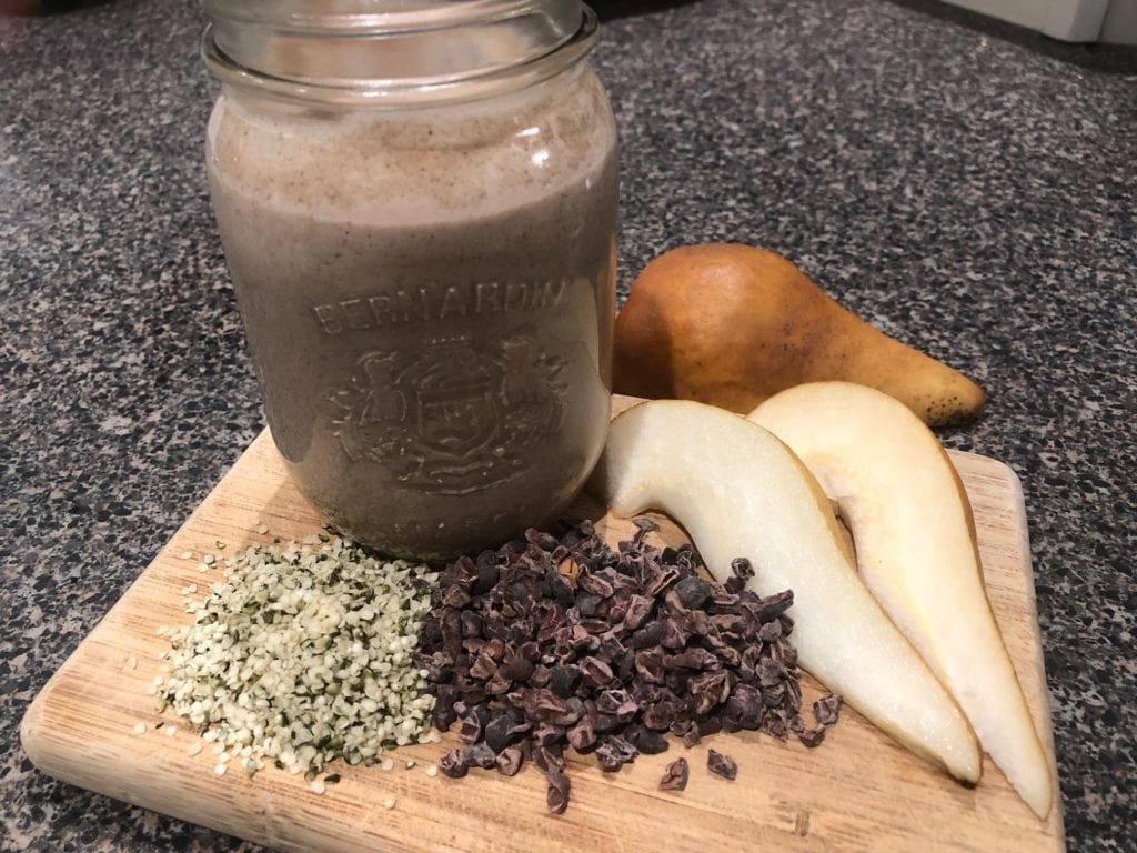 Ingredients on a cutting board with a Raw Cacao Hemp Seed Smoothie