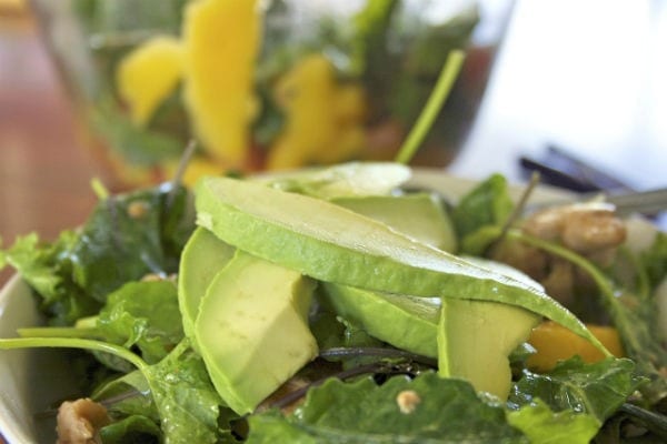 Closeup of an arugula salad with mango and avocado