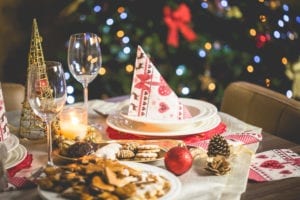Closeup of christmas dinner table with cookies and a wine glass and party hat for surviving the holidays