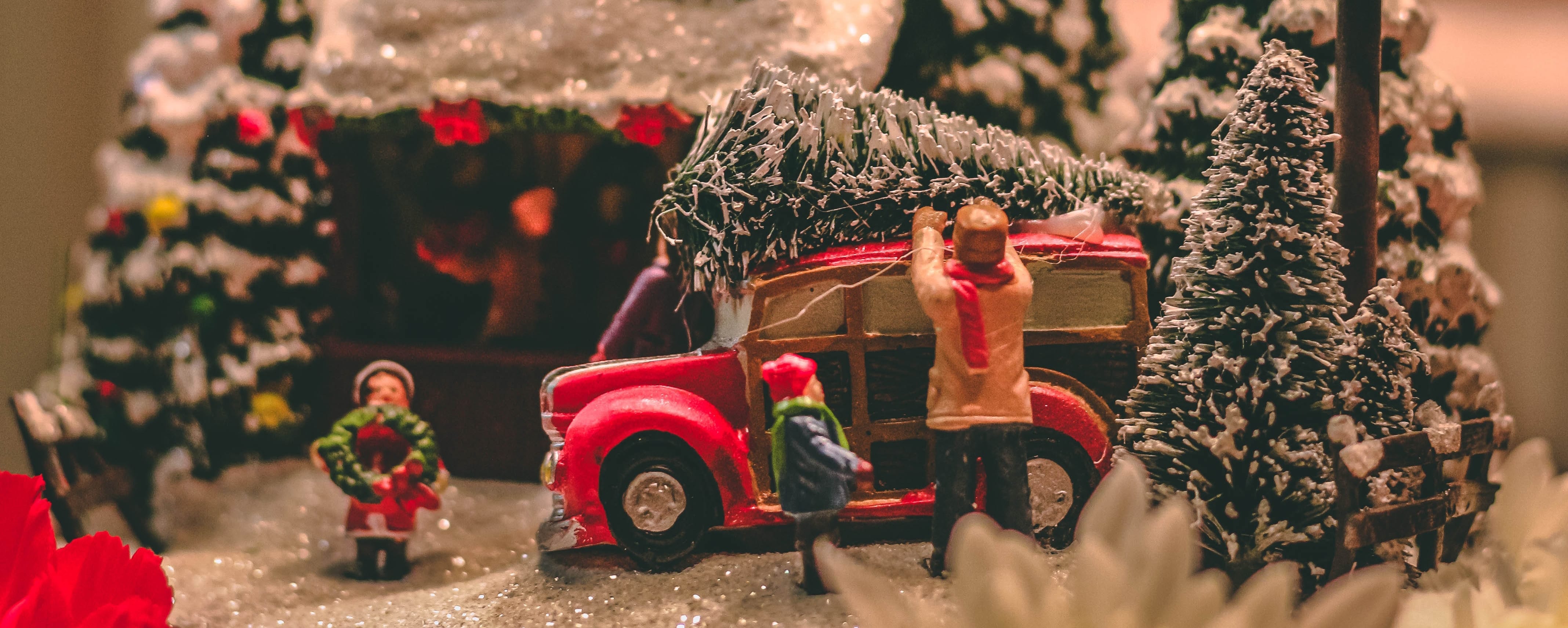 Model dad and children putting christmas tree on vehicle with snow, highlighting surviving the holidays