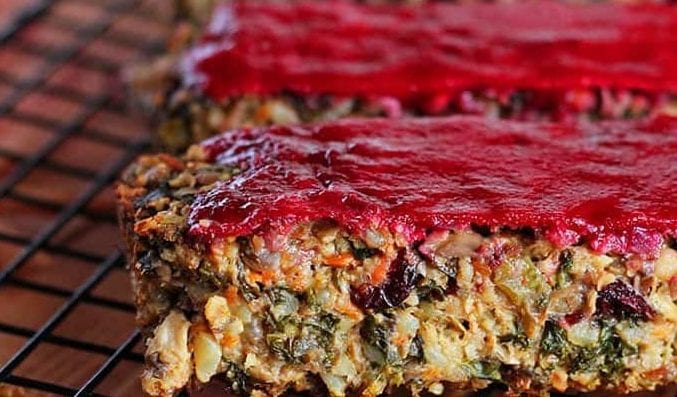 closeup of a vegan thanksgiving loaf with cranberry glaze on a rack out of the oven