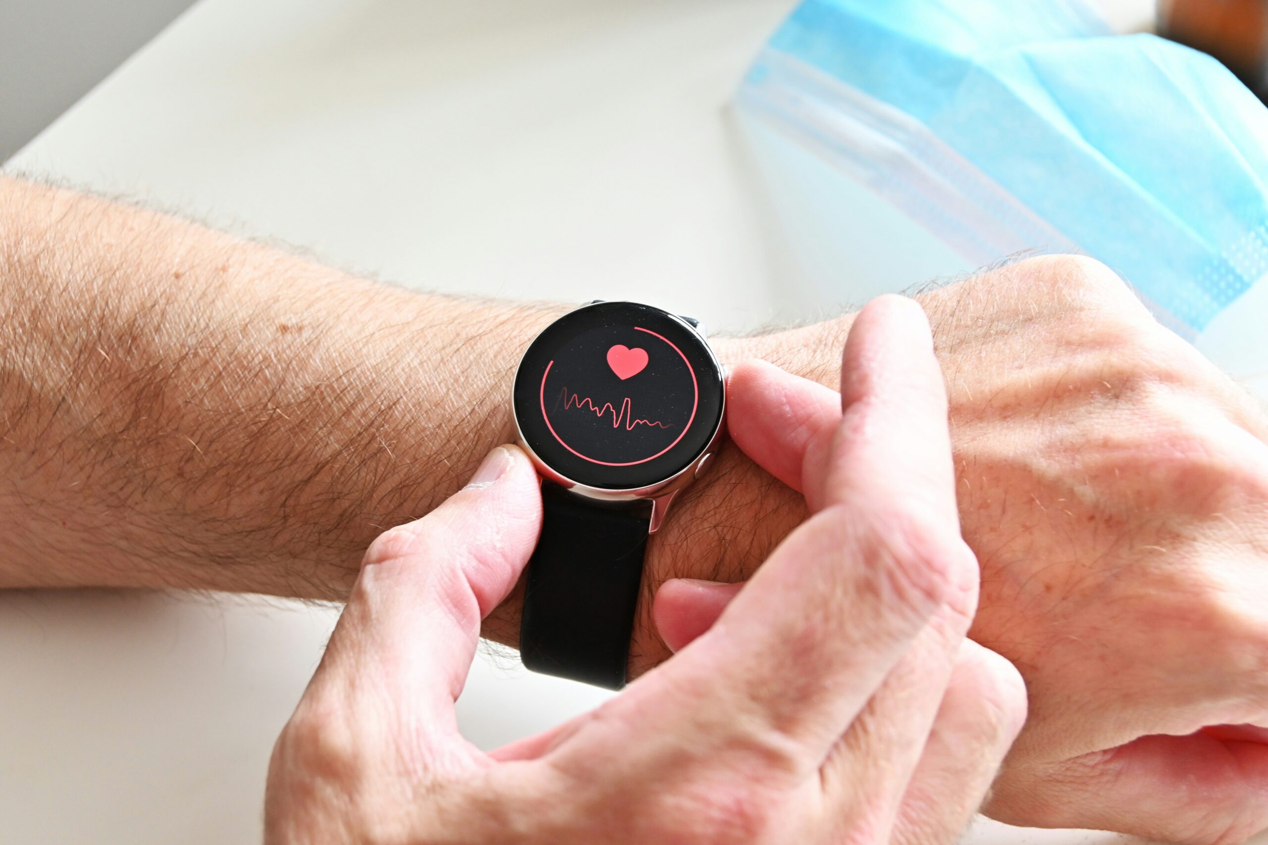 Person wearing a heart monitor on their wrist and looking at their heart rate reading as part of their strategy for maintaining a healthy heart.