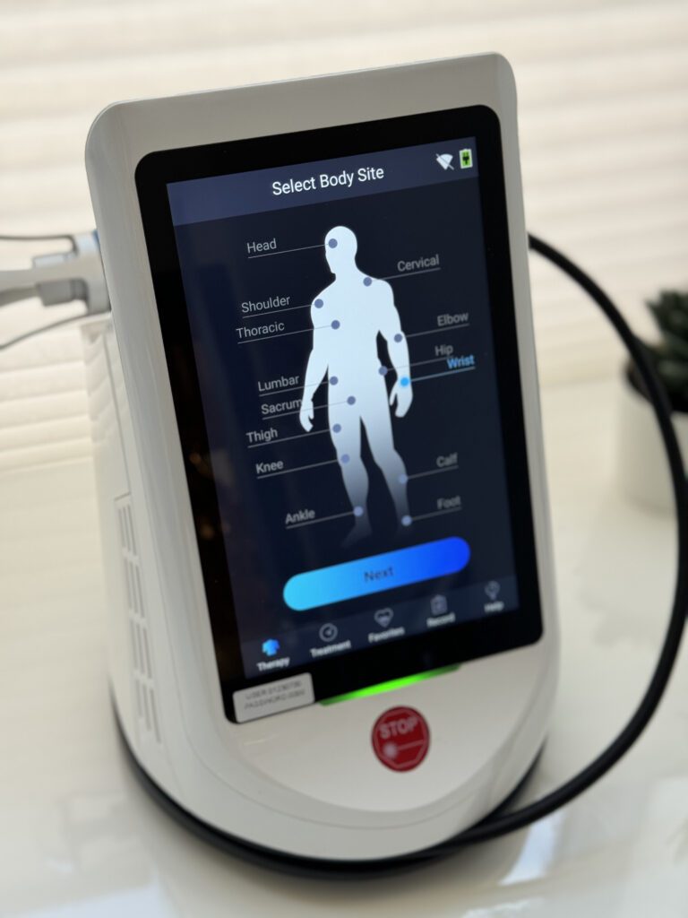a Cold Laser Therapy machine turned on showing a silhouette of a person, with the words Select Body Site on the screen