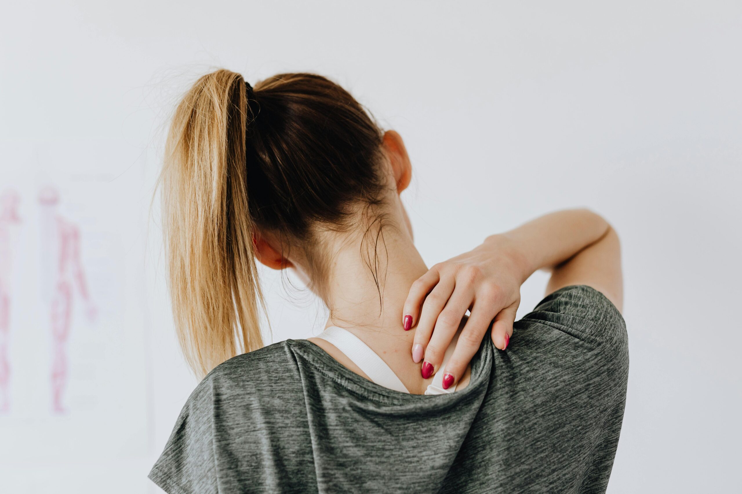 Woman holding her upper back feeling back pain.